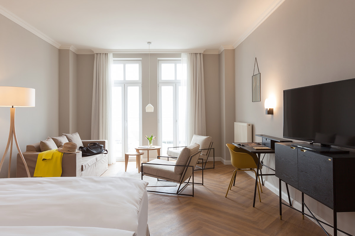 Spacious room at the Vju Hotel with elegant furnishings, floor-to-ceiling windows and stylish furniture for maximum comfort on Rügen.