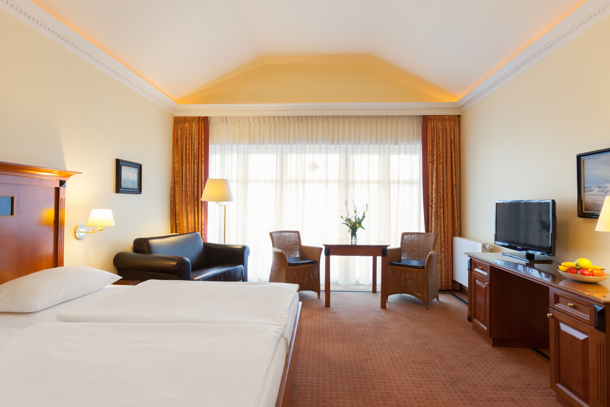 Large double room with cozy bed and warm atmosphere in the Vju Hotel on Rügen with numerous vacation offers.