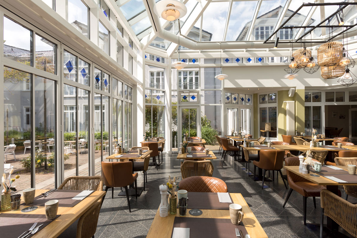 Inviting winter garden, part of the restaurant in the Vju Hotel, with culinary offers during your vacation on Rügen.