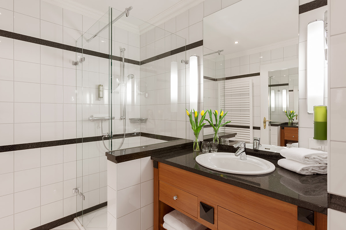 Helles Hotelbad mit Glasdusche, Kosmetikspiegel und frischen Handtüchern im Doppelzimmer der Dependancen des Vju Hotels.