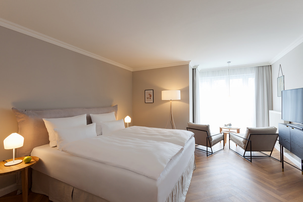 Hochwertig eingerichtetes Zimmer mit weichem Doppelbett im Doppelzimmer mit Ostseeblick des Vju Hotels.