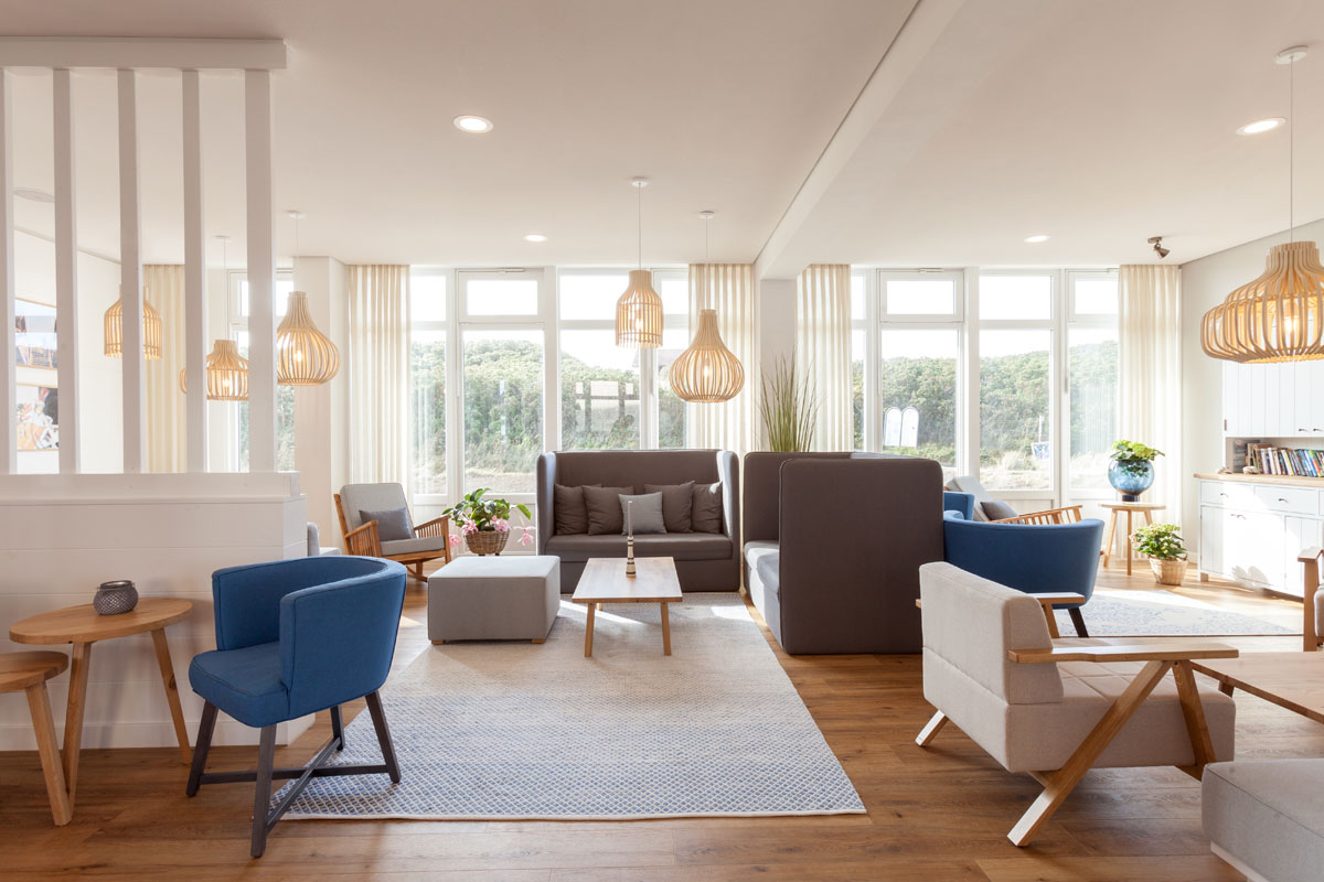 Bright and comfortably furnished lounge with armchairs and sofas in the Wyn. Strandhotel with many vacation offers.