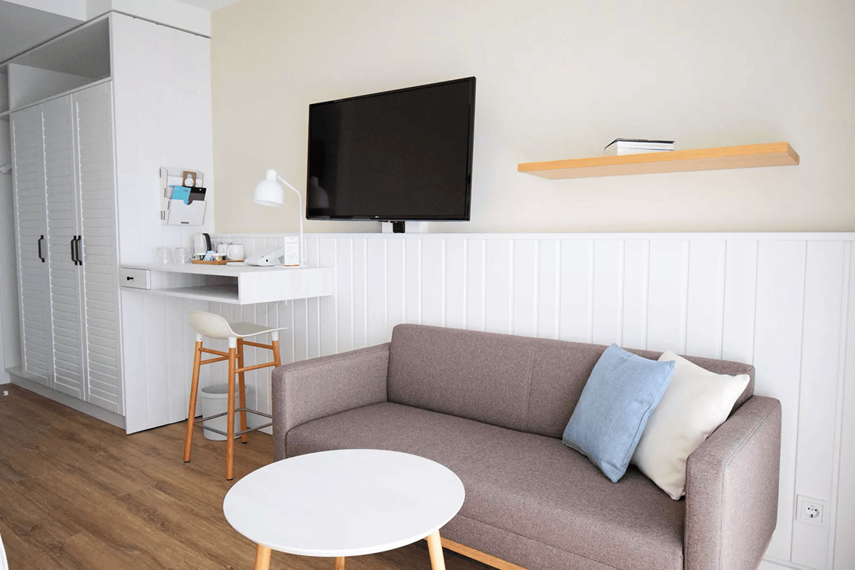 Cozy sitting area with stylish sofa in the Shell Seeker room of the Wyn. Strandhotel for relaxing moments on Sylt.