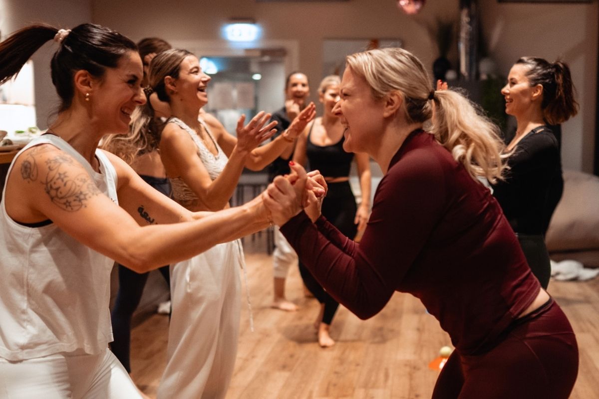 Zwei Teilnehmerinnen bei einer kraftvollen Partnerübung während des Powerful You Retreats im Wyn Strandhotel Sylt.