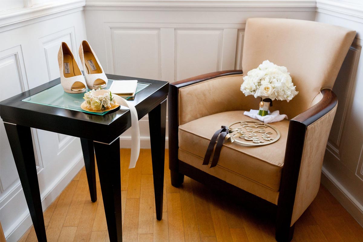 Wedding accessories, bridal shoes and flowers on a table and an armchair in the Hotel Elephant Weimar.
