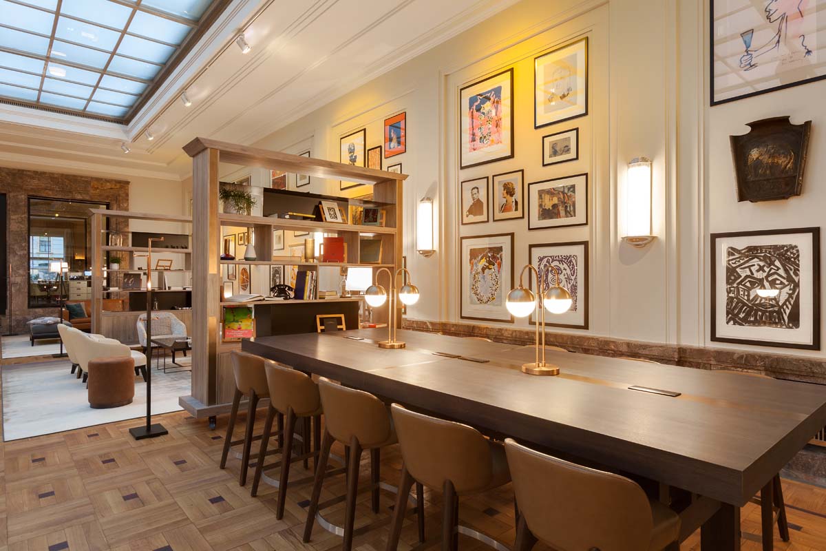 Modern meeting room in the Hotel Elephant Weimar with a long wooden table, art on the walls and stylish lights.
