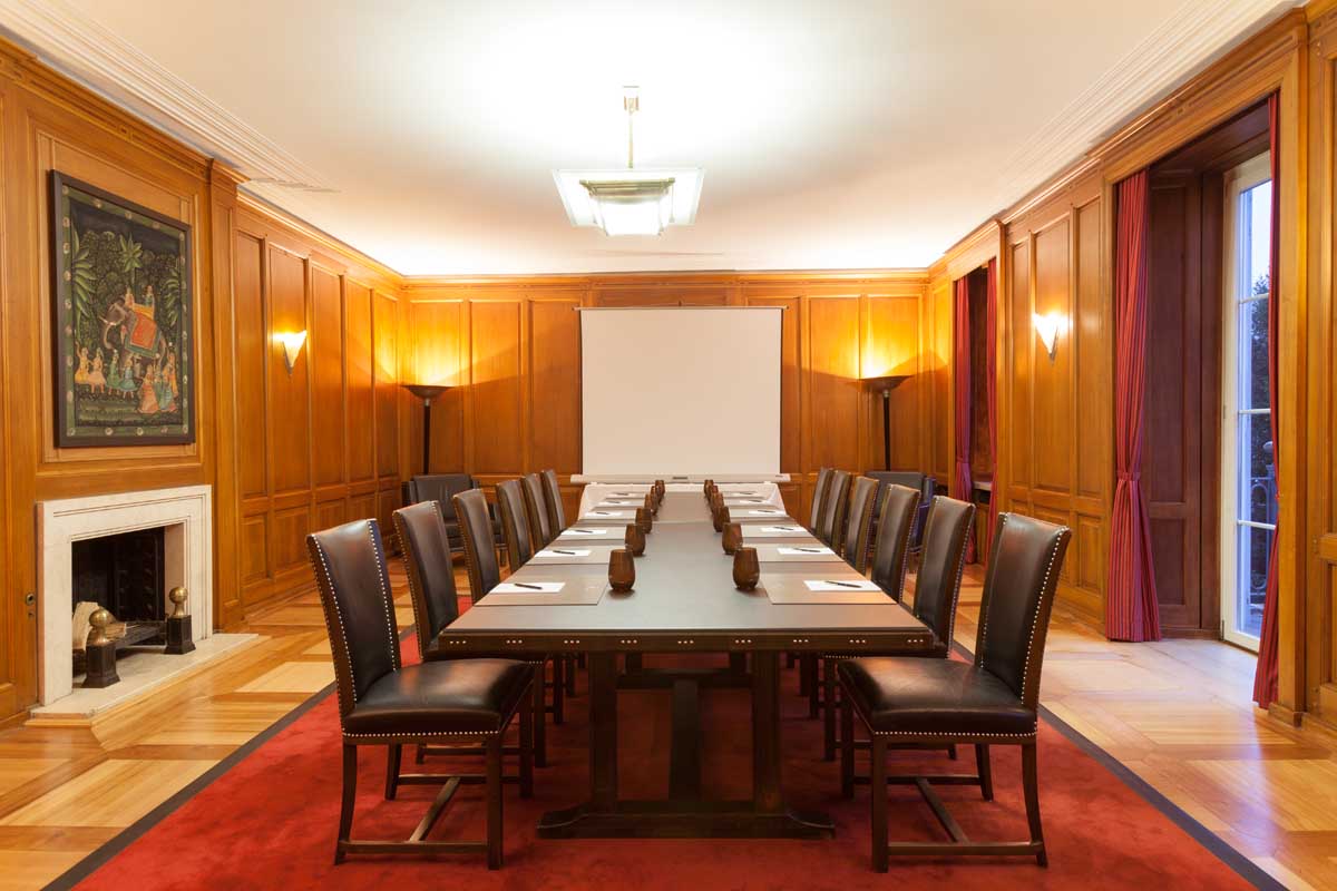 Meeting room at the Hotel Elephant Weimar with a large conference table, leather chairs and wood paneling ready for conferences.