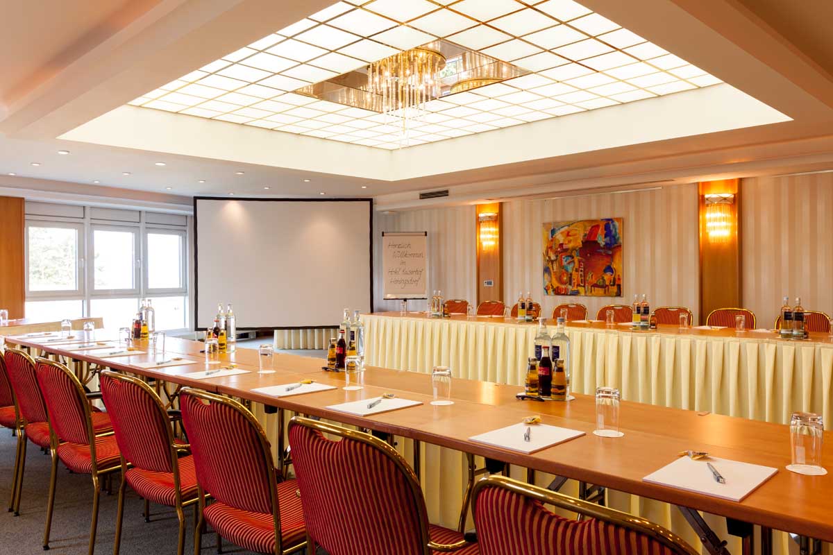 Spacious conference room in the Hotel Kaiserhof Heringsdorf, equipped with modern tables, chairs and presentation technology.