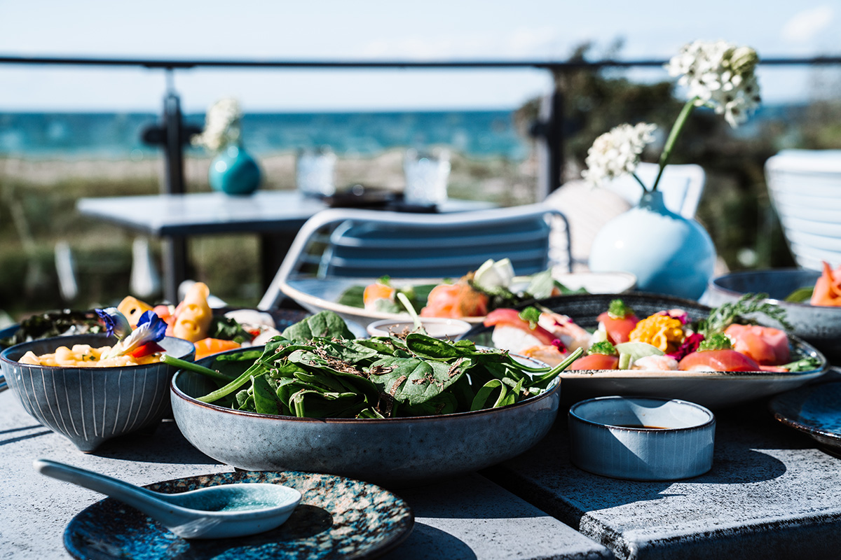 Table with various fresh salads and appetizers for a wedding reception in the Seezeichen artist quarter with a sea view.