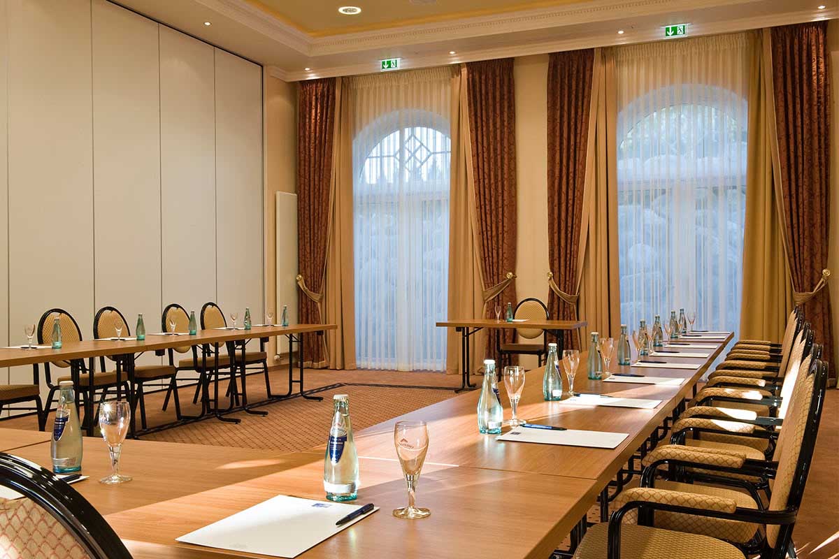 Bright meeting room in the Vju Hotel on Rügen with long conference tables, water bottles and writing materials for meetings.